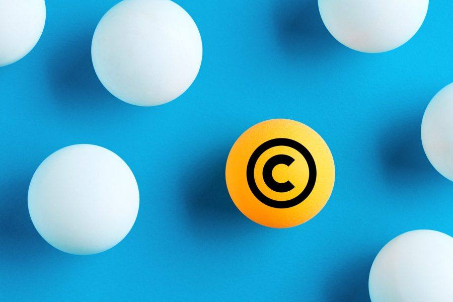 Orange boll med copyright-symbolen bland vita bollar på blå bakgrund
